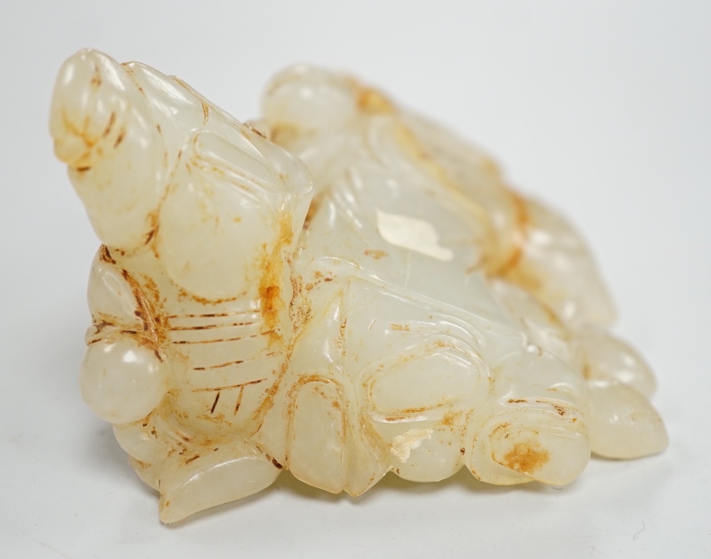 A Chinese white and russet jade group of three boys, 18th/19th century, 7.2 cm, wood stand